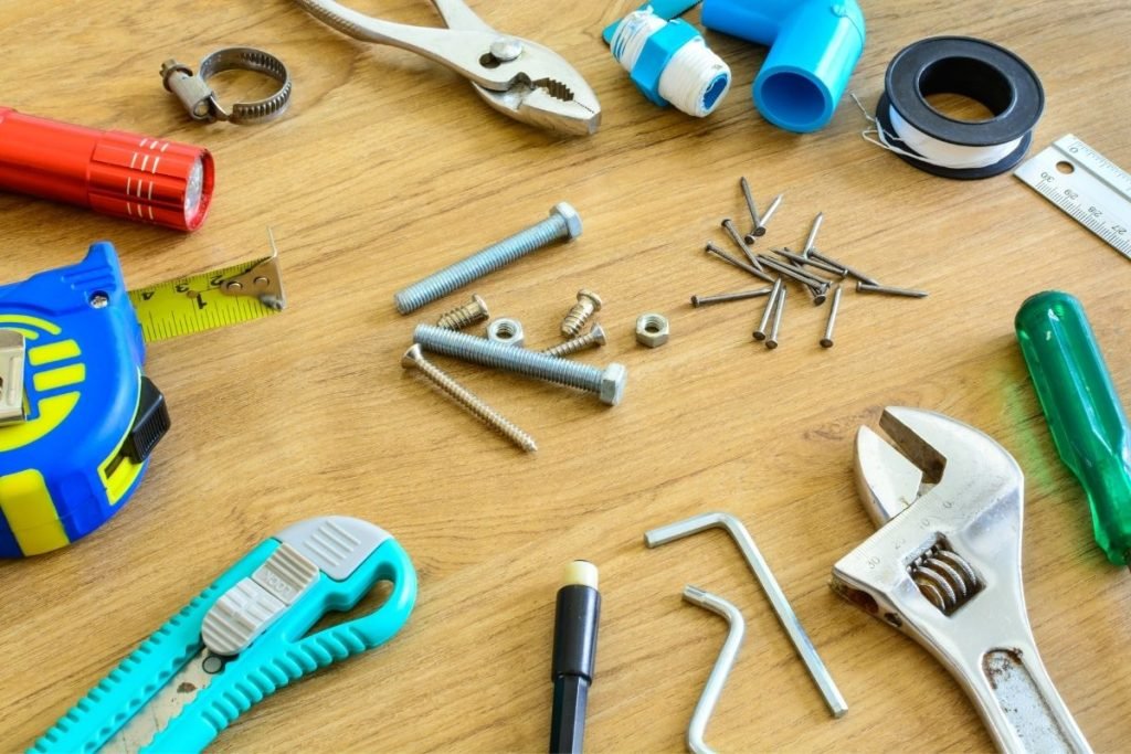 A wooden table displaying various tools, including a ruler, tape measure, and pliers, arranged neatly for use.